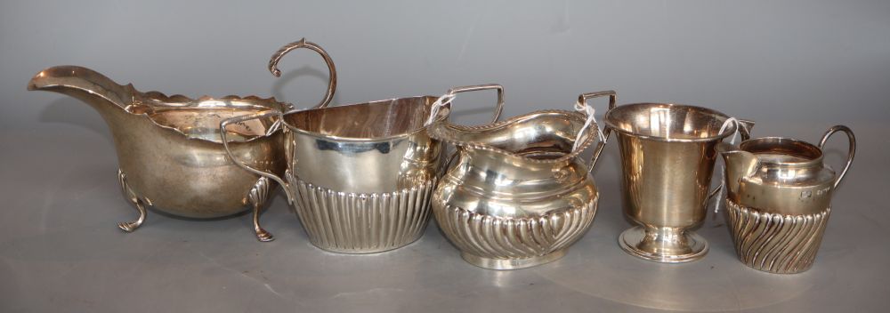 A small silver Christening mug, two silver cream jugs, a silver sauceboat and a sugar bowl, various dates